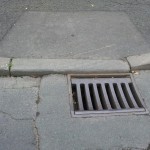 A surface drain in front of a dropped kerb A surface drain in front of a dropped kerb